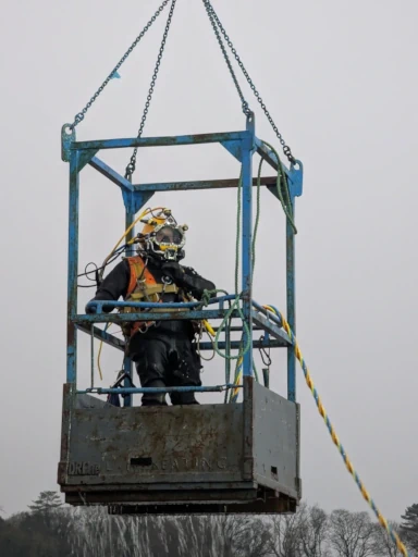 Diver in the cage on crane